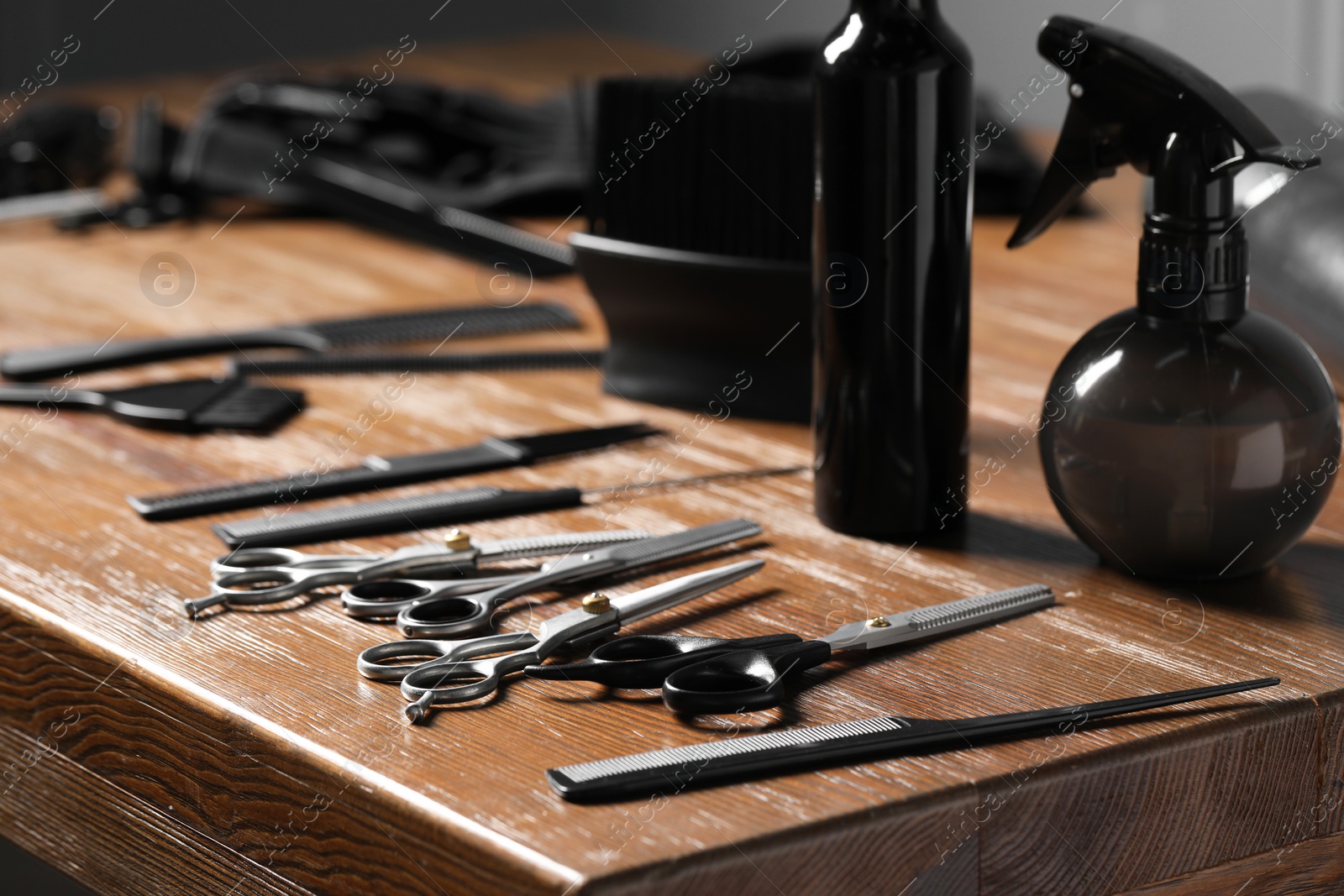 Photo of Hairdresser tools. Different scissors and combs on wooden table, closeup