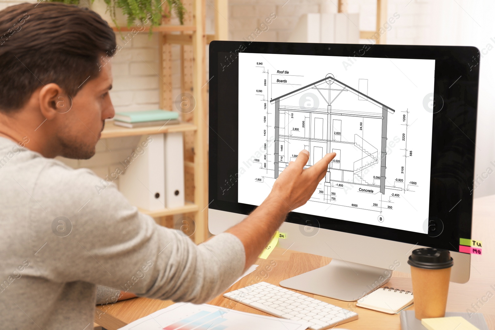 Image of Architect making project of house on computer in office