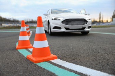 Photo of Modern car at test track, focus on traffic cone. Driving school