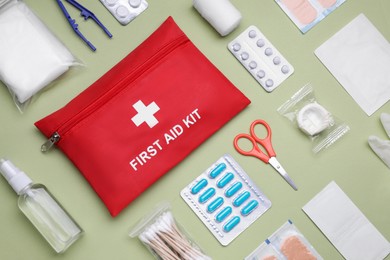 Photo of Flat lay composition with first aid kit on light green background
