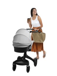 Happy young woman with cup of drink and baby stroller on white background