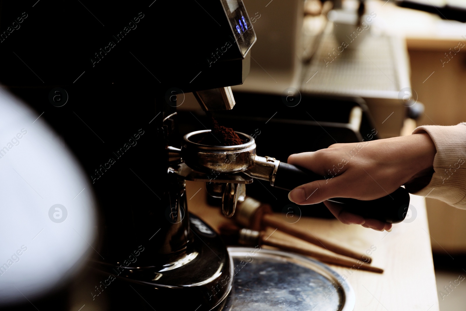 Photo of Barista preparing coffee using modern machine, closeup