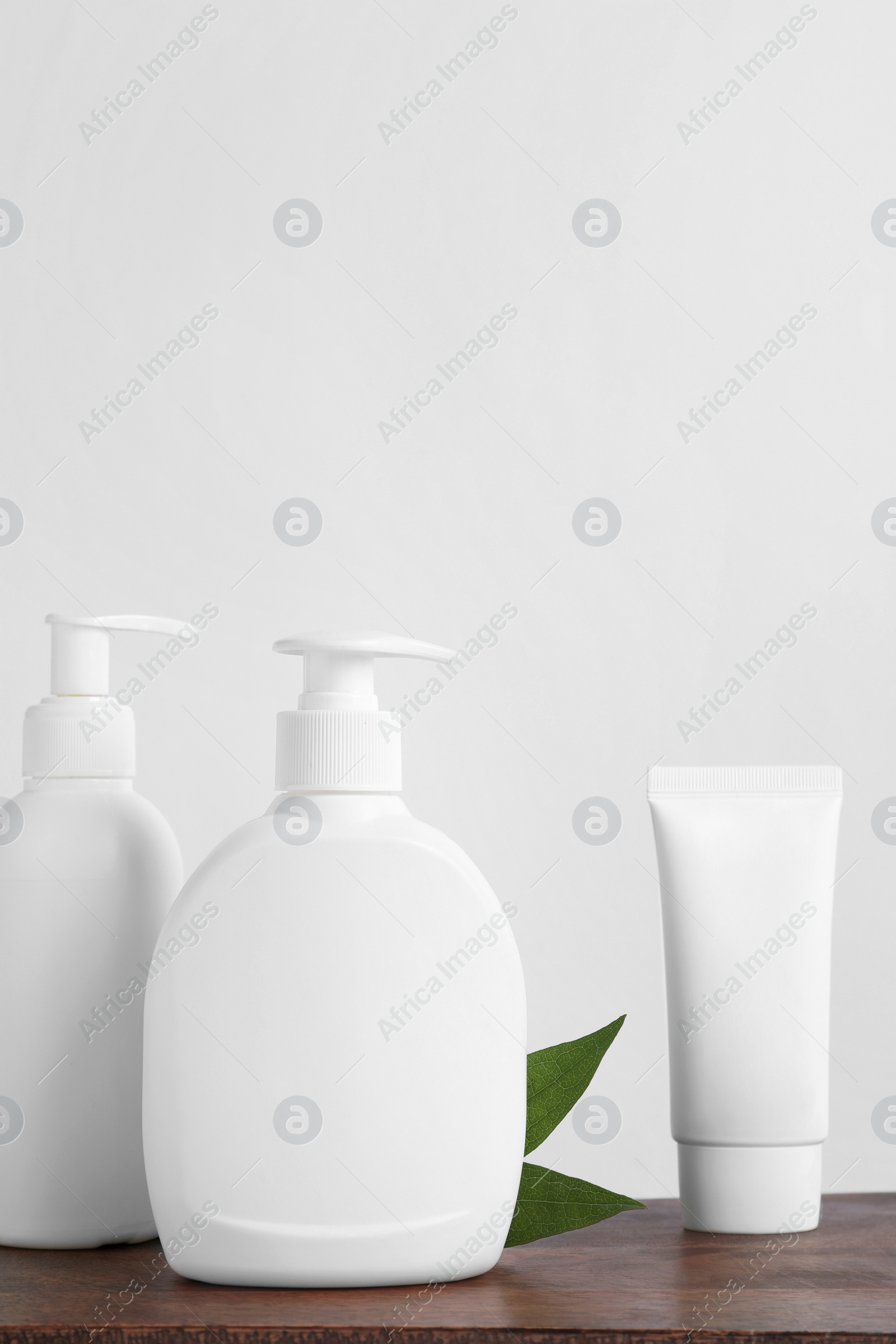 Photo of Bottles with different cosmetic products on wooden table