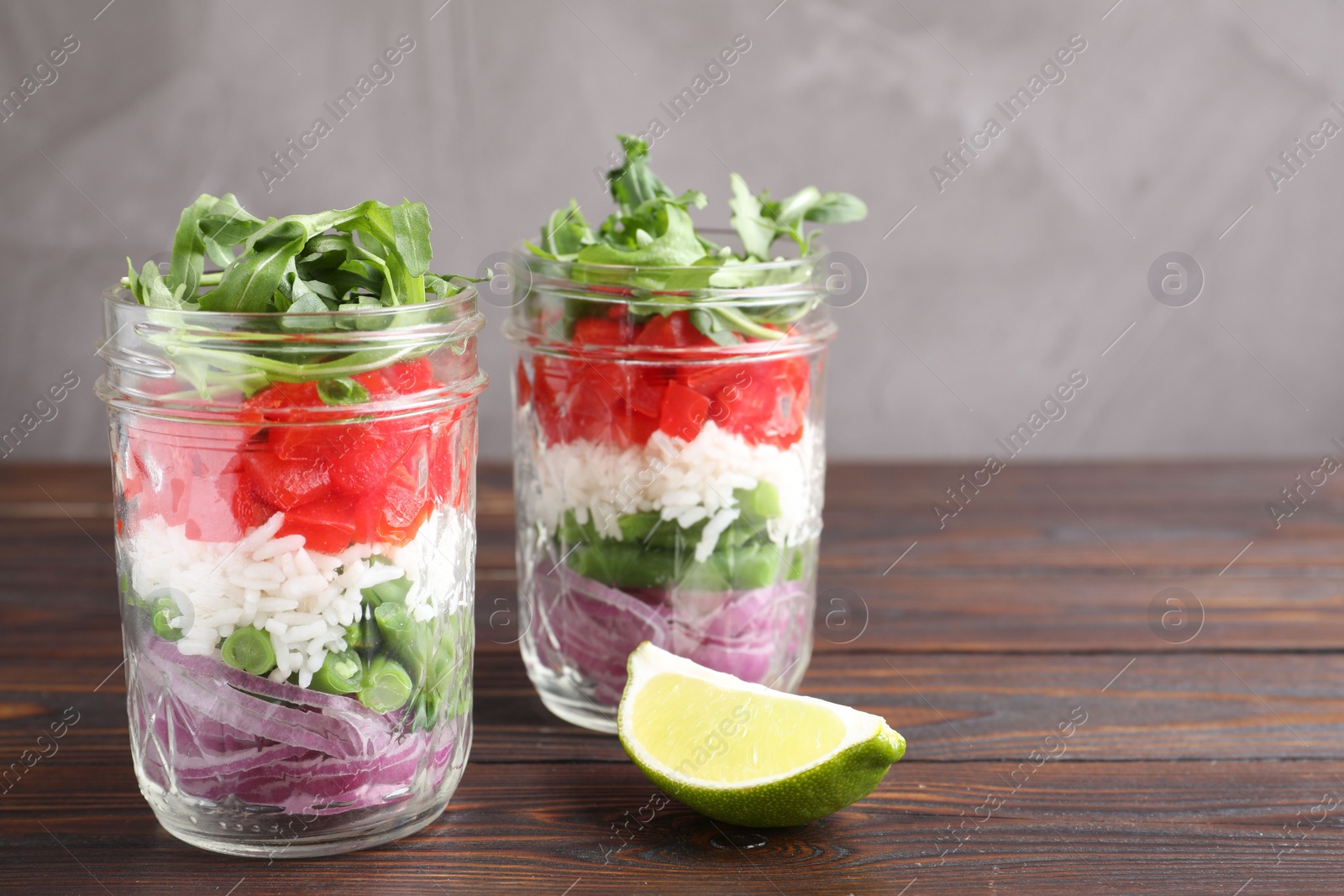 Photo of Healthy salad in glass jars on wooden table