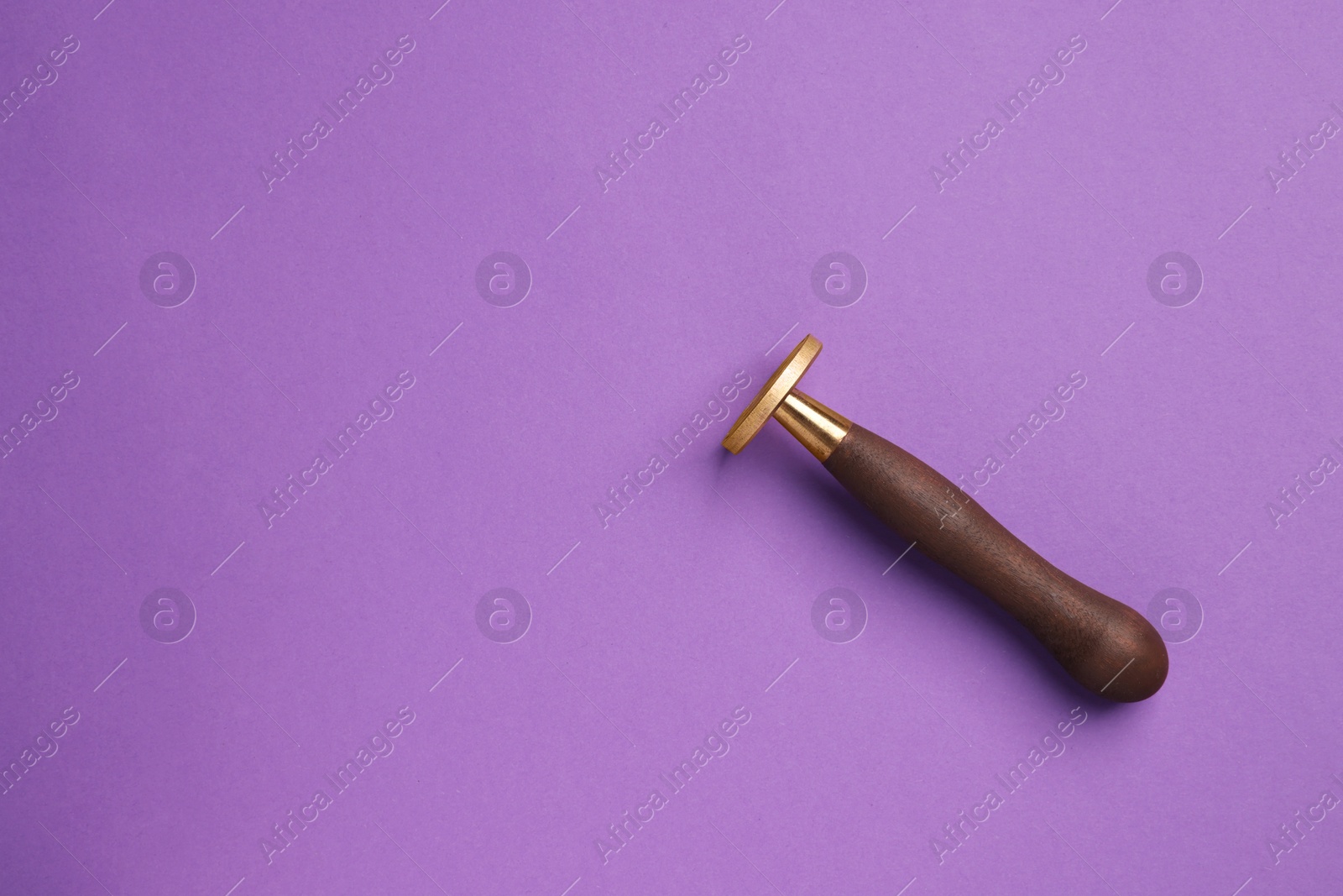 Photo of One stamp tool with wooden handle on purple background, top view. Space for text