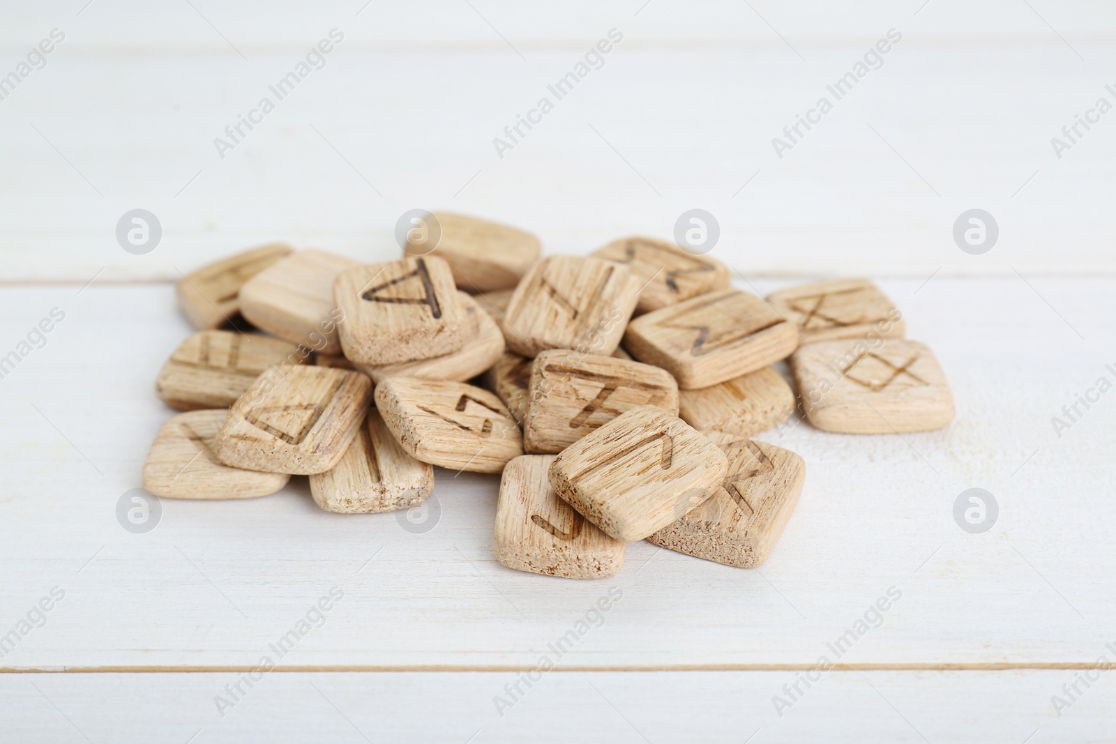 Photo of Pile of runes on white wooden table