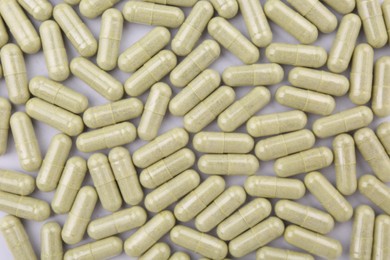 Photo of Many vitamin capsules on white background, flat lay
