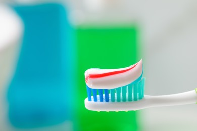 Photo of Toothbrush with paste against blurred background, closeup