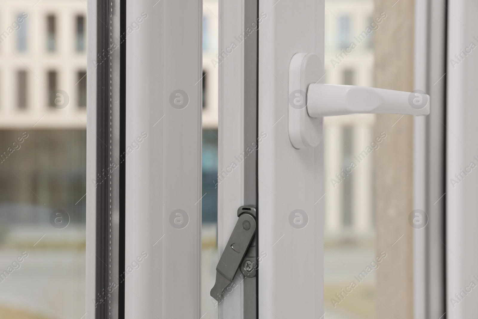 Photo of Open window with white plastic frame indoors, closeup