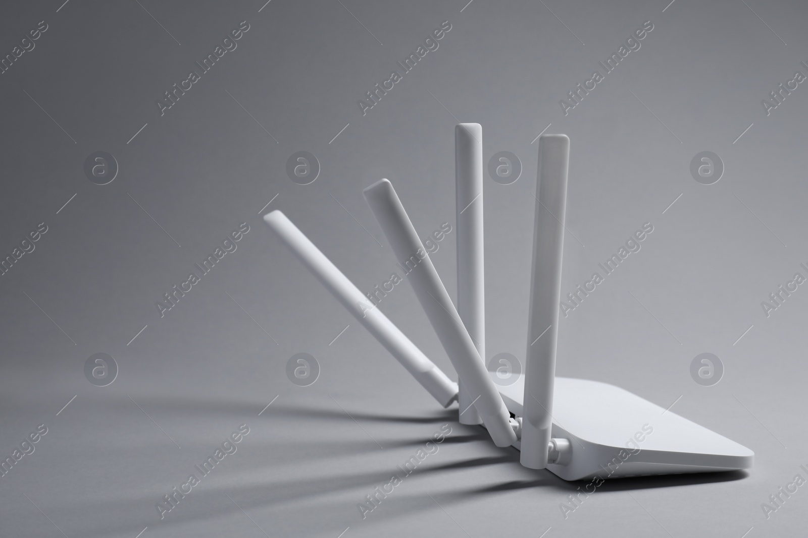 Photo of New stylish Wi-Fi router on grey background. Space for text