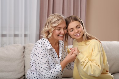 Photo of Young woman with her mom at home. Happy Mother's Day