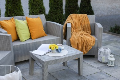 Photo of Beautiful rattan garden furniture, soft pillows and different decor elements outdoors