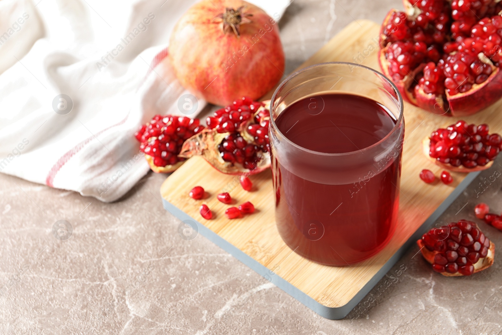 Photo of Composition with glass of fresh pomegranate juice on table. Space for text