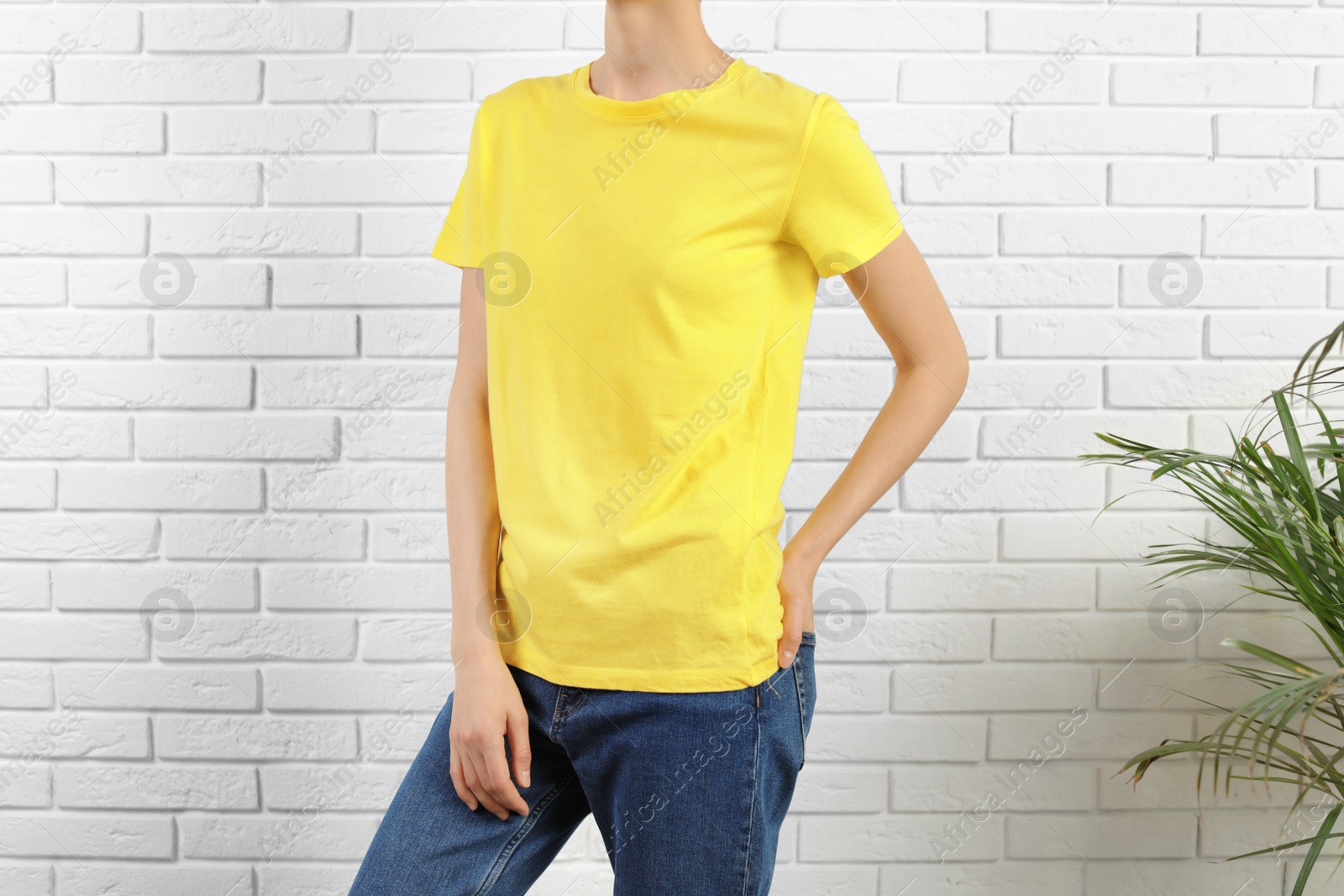 Photo of Woman in bright t-shirt near brick wall. Mock up for design