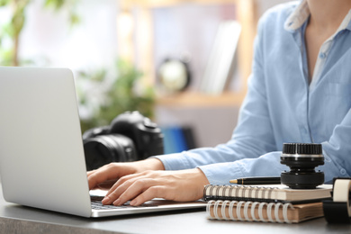 Photo of Journalist working with laptop at table, closeup