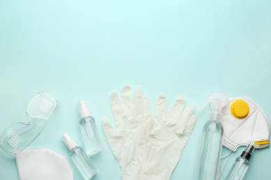 Photo of Flat lay composition with medical gloves, masks and hand sanitizers on light blue background. Space for text