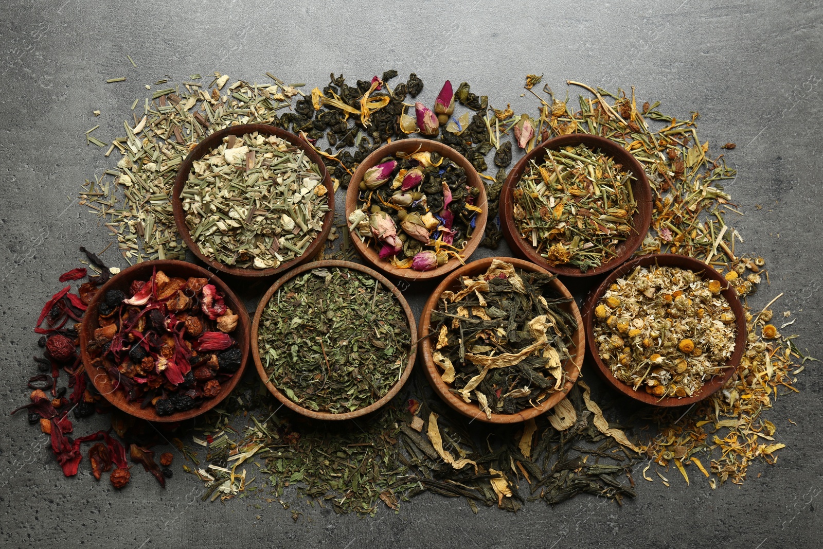 Photo of Flat lay composition with different dry teas on grey table