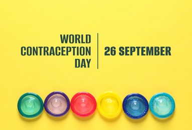 World contraception day. Many colorful condoms on yellow background, flat lay