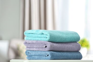 Stack of folded clean soft towels on table indoors