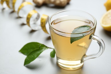 Photo of Herbal diet tea and measuring tape on light table