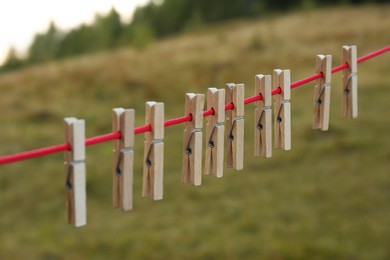 Wooden clothespins hanging on washing line outdoors