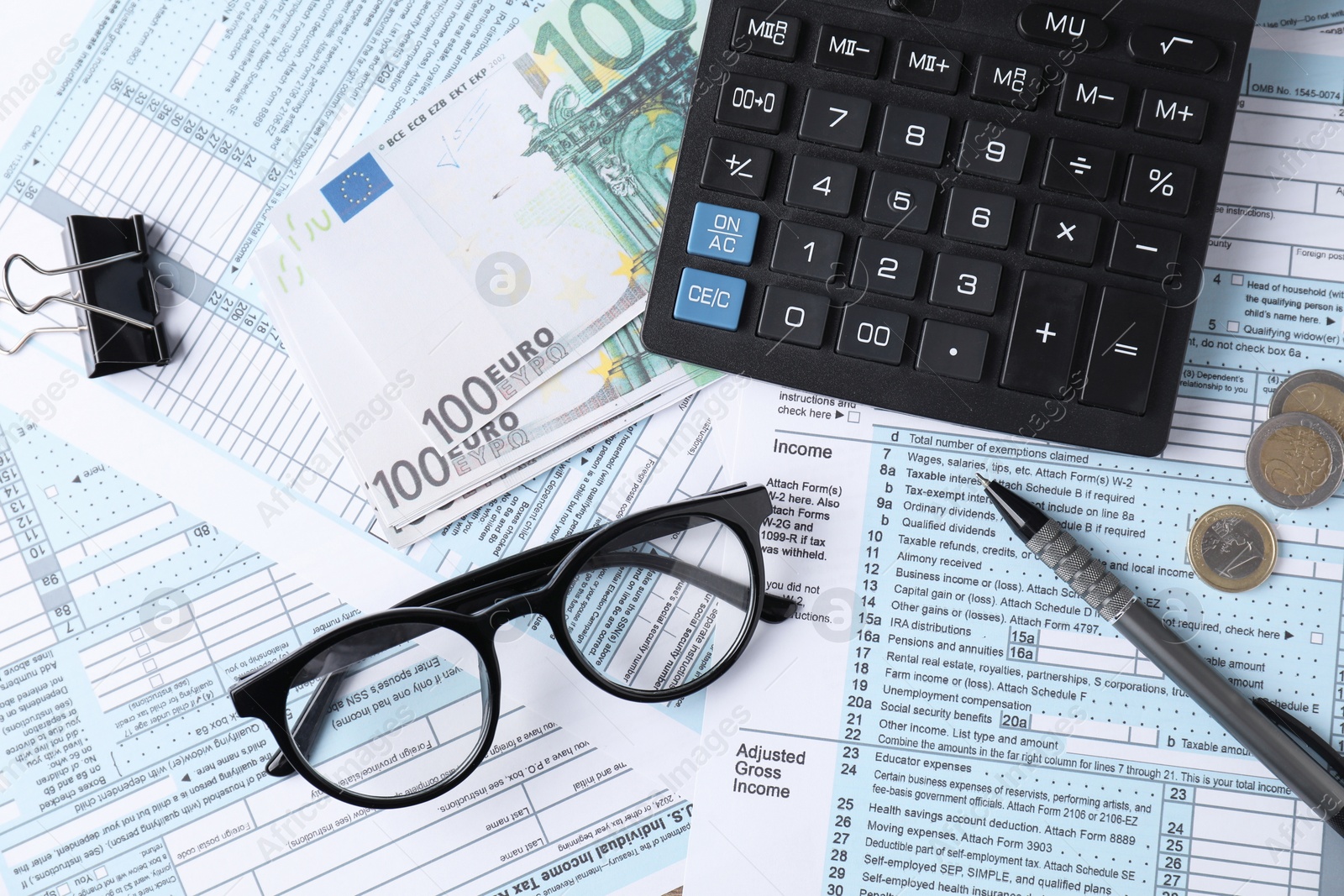 Photo of Tax accounting. Calculator, money, glasses and stationery on documents, flat lay