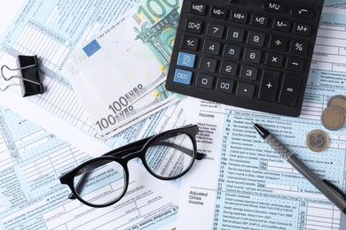 Tax accounting. Calculator, money, glasses and stationery on documents, flat lay