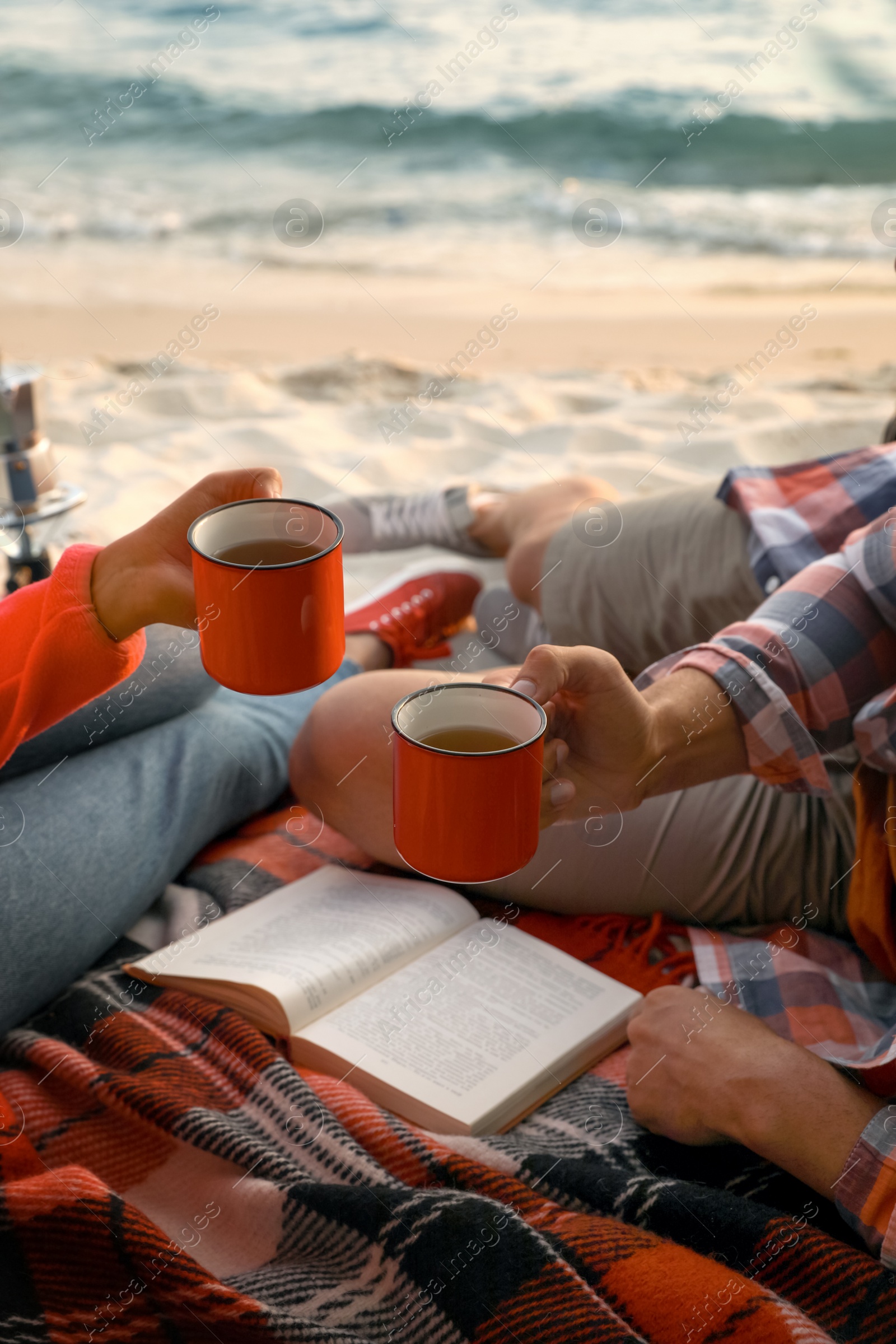 Photo of Couple resting near sea, closeup. Beach camping