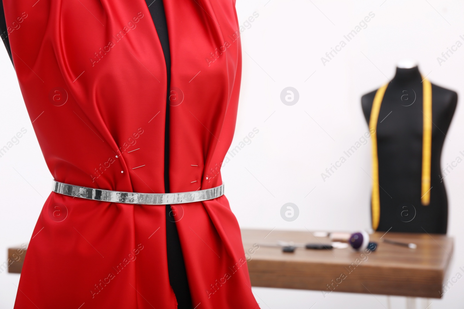 Photo of Mannequin with red cloth in tailor studio