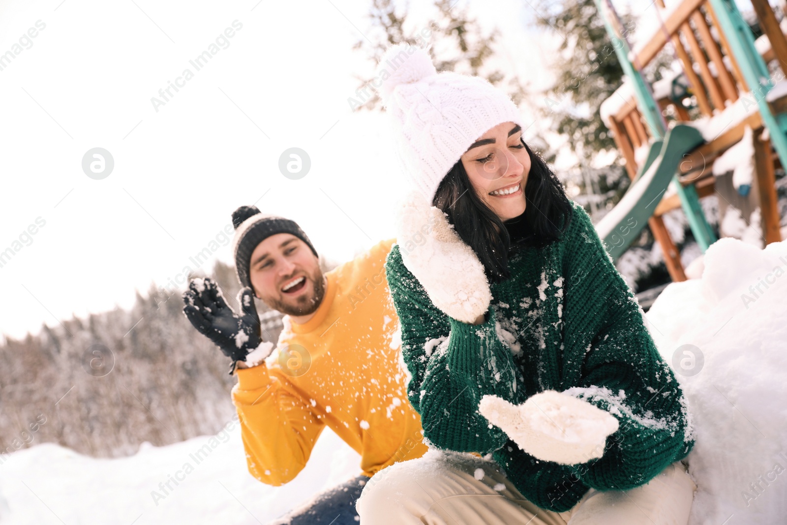 Photo of Happy couple playing snowballs outdoors. Winter vacation