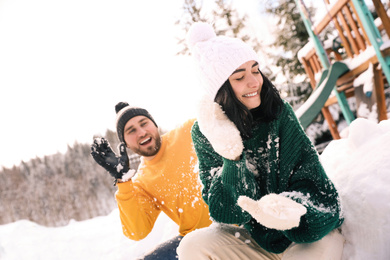 Photo of Happy couple playing snowballs outdoors. Winter vacation