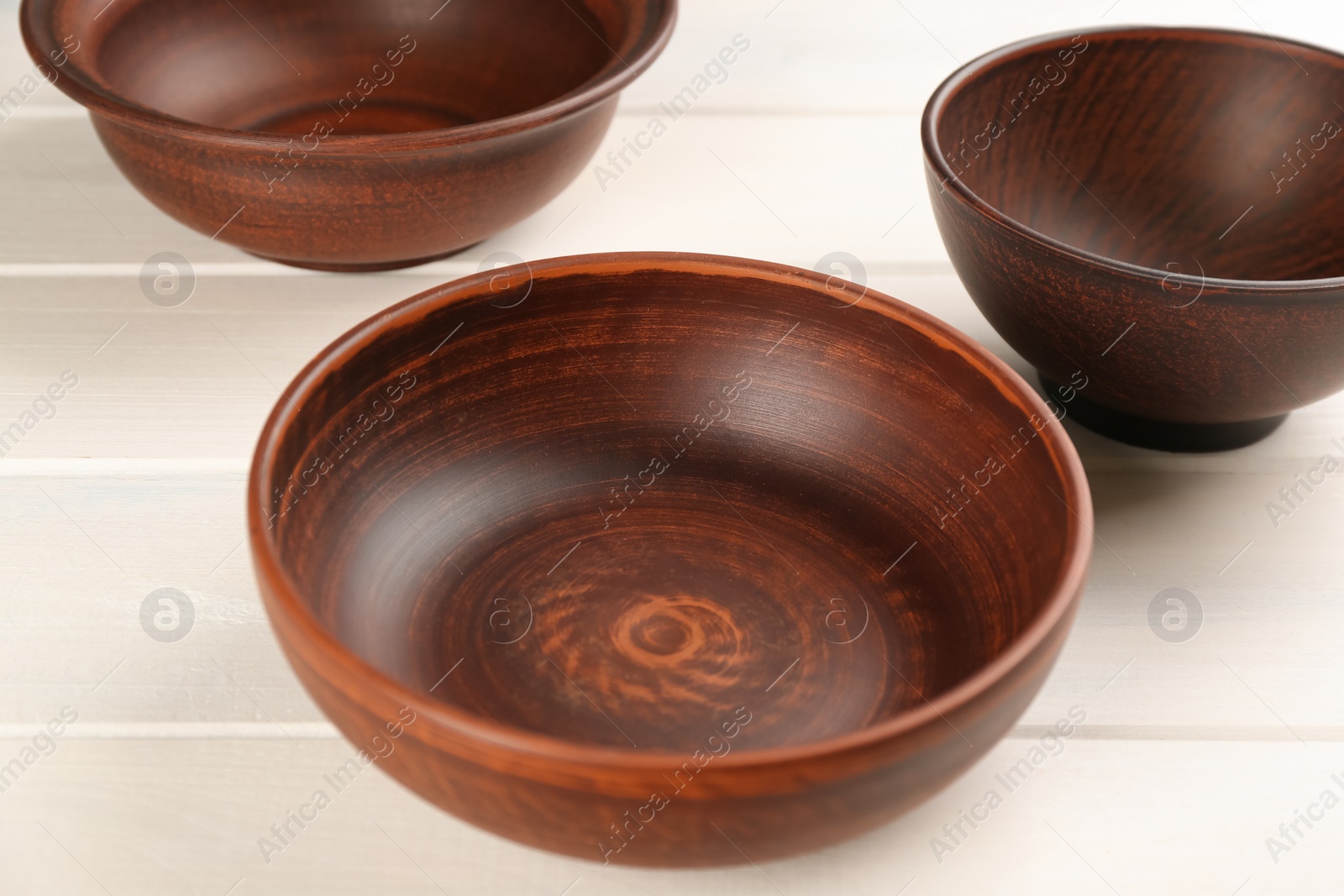 Photo of Beautiful clay bowls on white wooden table