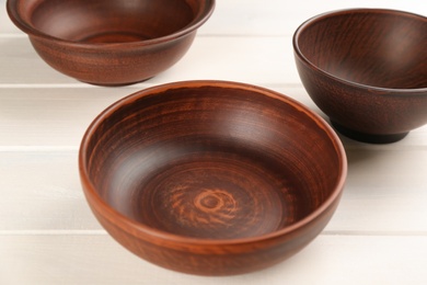 Photo of Beautiful clay bowls on white wooden table
