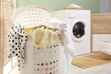 Laundry basket filled with clothes in bathroom, closeup. Space for text