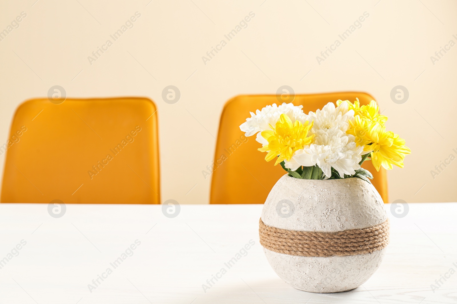 Photo of Vase with blooming flowers on table indoors