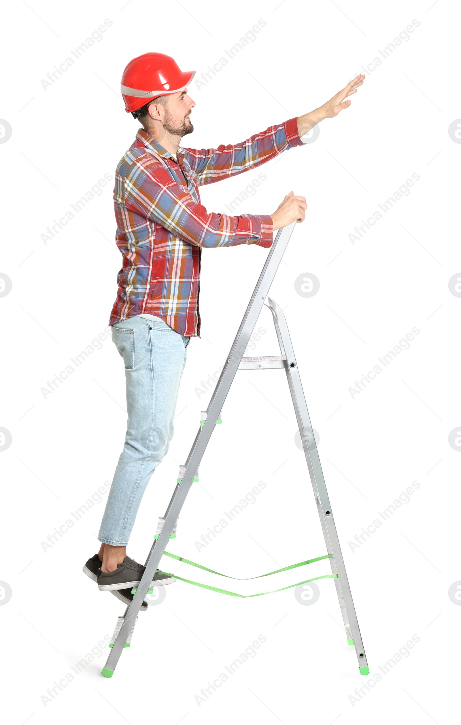 Photo of Young handsome man in hard hat climbing up metal ladder on white background