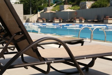 Photo of Empty sunbed near outdoor swimming pool at resort