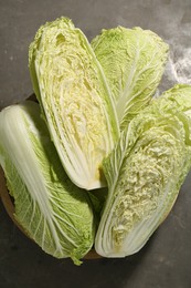 Photo of Fresh ripe Chinese cabbages in bowl on gray table, top view