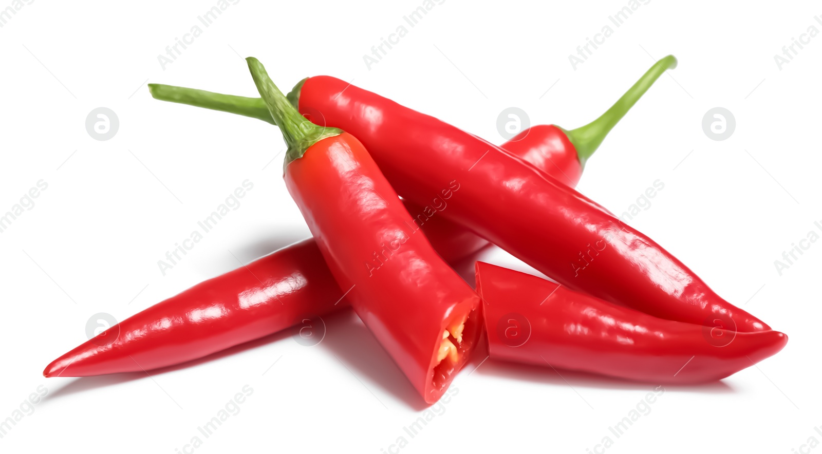 Photo of Cut and whole red hot chili peppers on white background