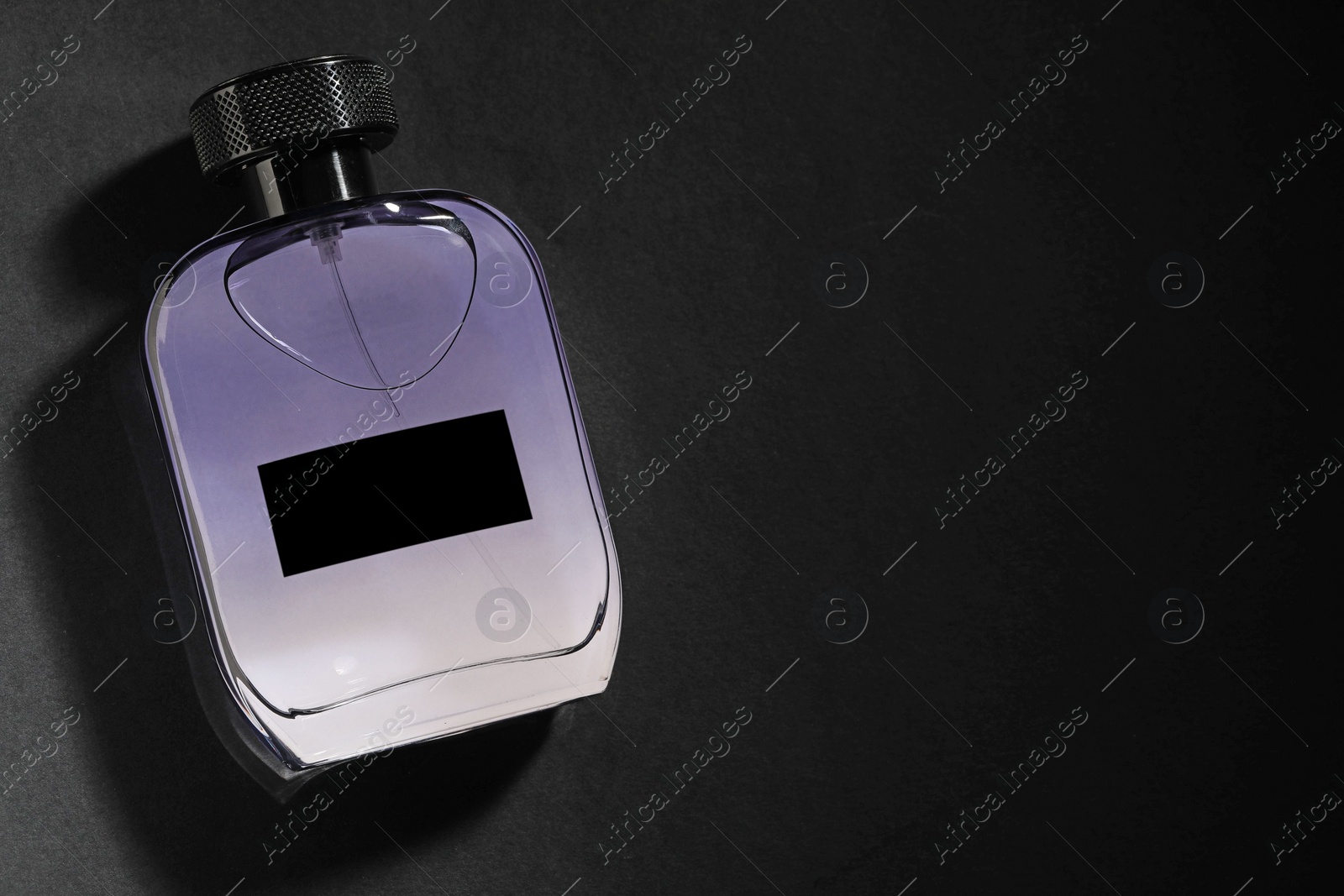 Photo of Luxury men`s perfume in bottle on black background, top view. Space for text