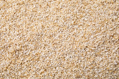 Photo of Raw barley groats as background, top view