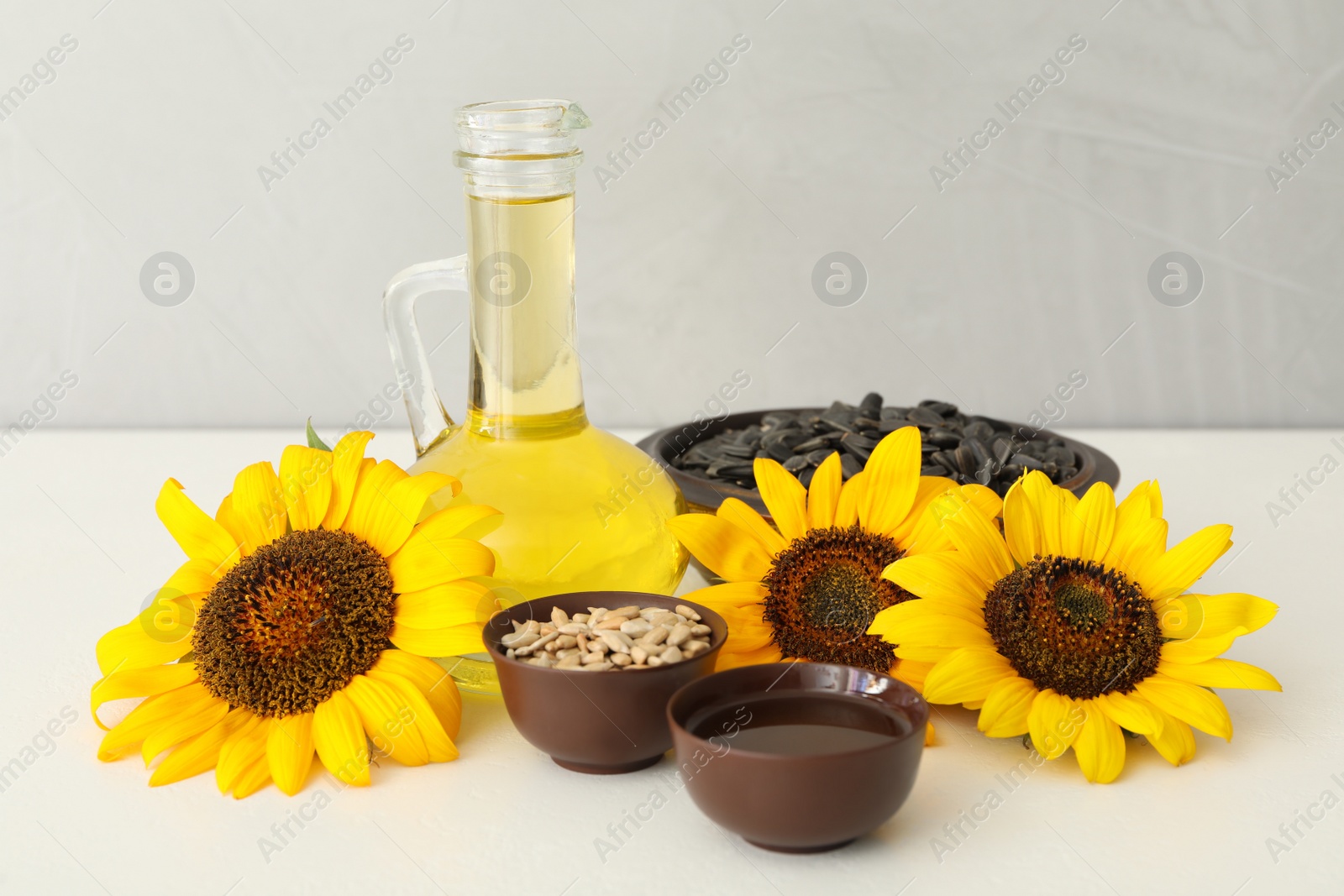 Photo of Composition with sunflower oil on white table