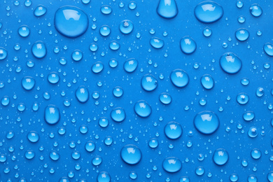 Water drops on blue background, top view