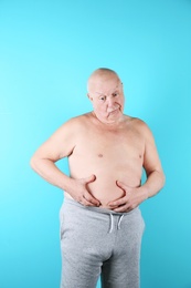 Photo of Fat senior man on color background. Weight loss
