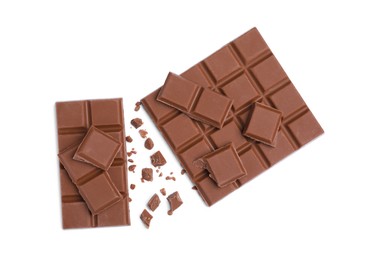 Pieces of delicious milk chocolate bars on white background, top view