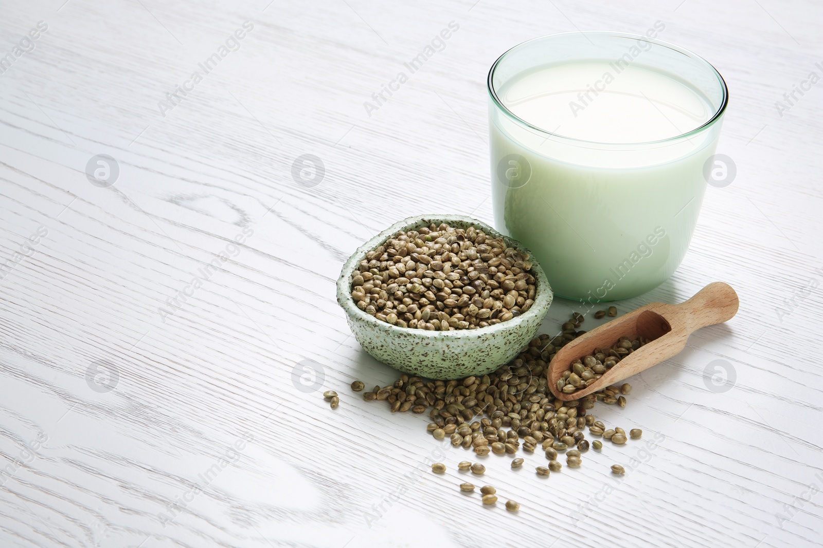 Photo of Hemp seeds and glass of milk on wooden background