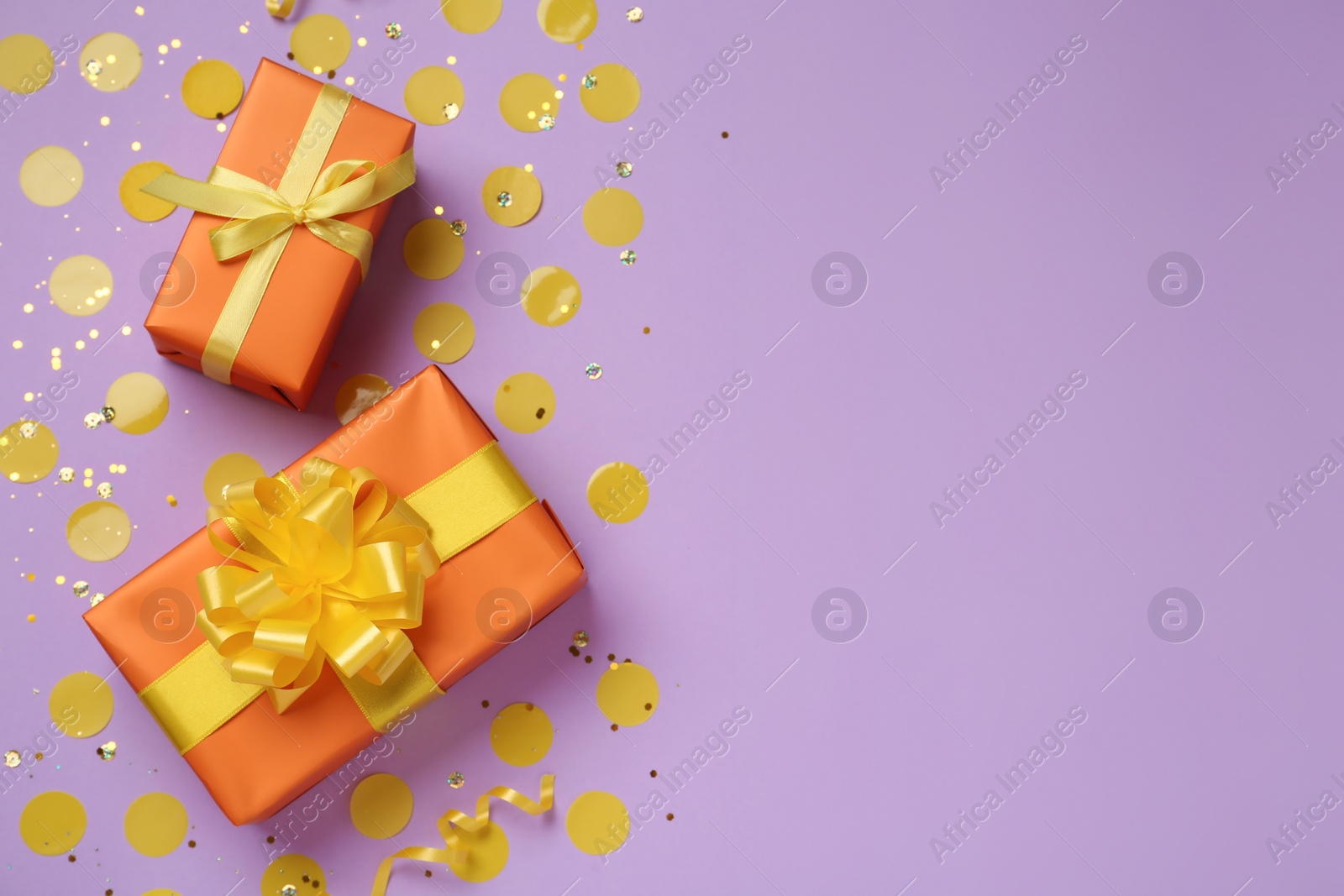Photo of Orange gift boxes and confetti on lilac background, flat lay. Space for text