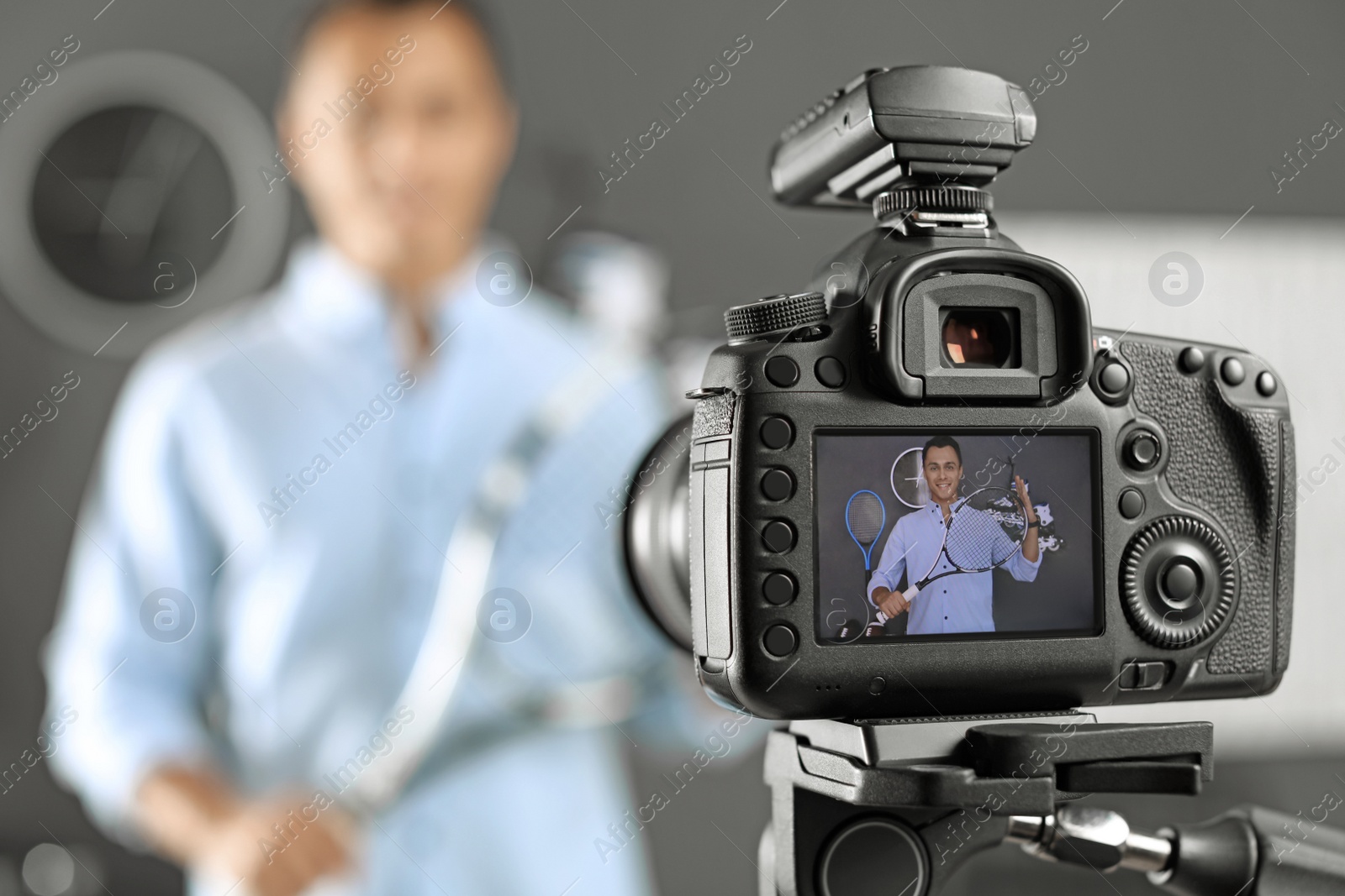 Photo of Sport blogger recording video indoors, selective focus on camera display. Space for text