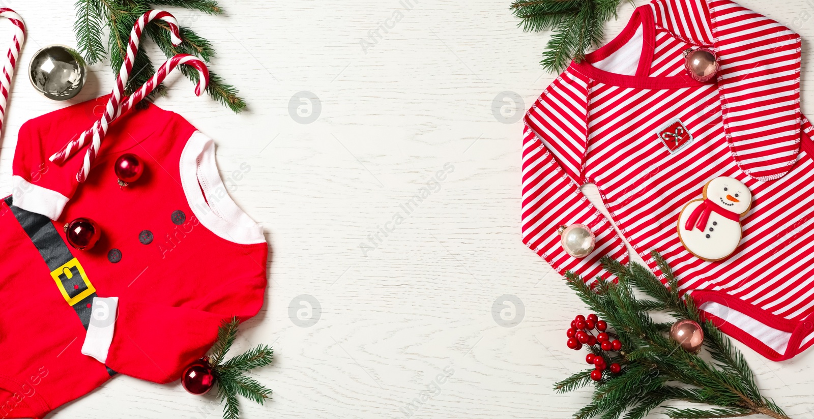 Photo of Flat lay composition with cute Christmas baby clothes on white wooden background. Space for text