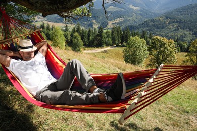 Man resting in hammock outdoors on sunny day